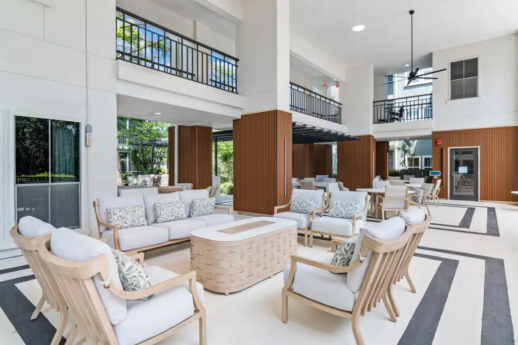 model living room with modern furniture, television, and door open to a bedroom.